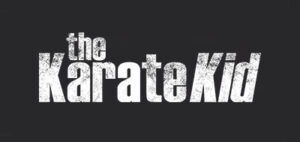 A bold, distressed logo for "The Karate Kid" movie with a gritty, textured black background and white text.